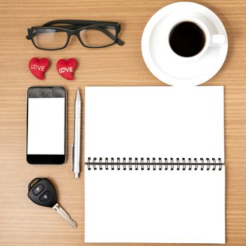 office desk : coffee and phone with car key,eyeglasses,notepad,heart on wood background