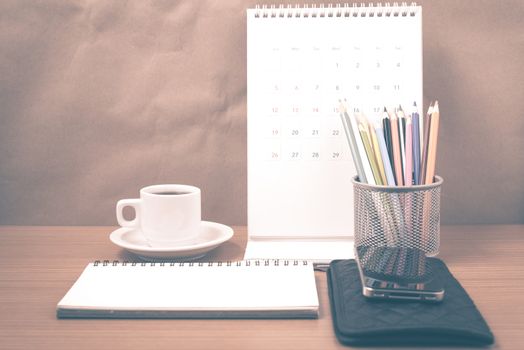office desk : coffee with phone,wallet,calendar,color pencil box,notepad on wood background vintage style