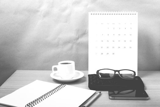 office desk : coffee with phone,calendar,wallet,notepad on wood background black and white color