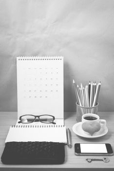 office desk : coffee with phone,wallet,calendar,heart,notepad,eyeglasses,color pencil box,key on wood background black and white color