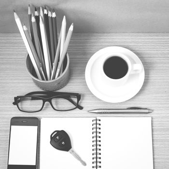 office desk : coffee and phone with key,eyeglasses,notepad,pencil box black and white color