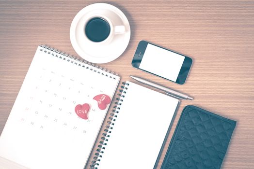 office desk : coffee with phone,wallet,calendar,heart,notepad on wood background vintage style