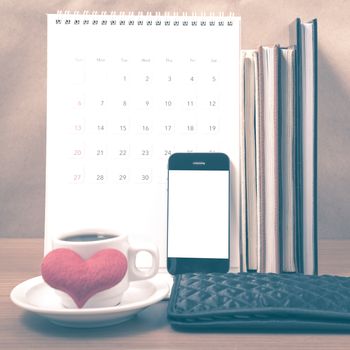 office desk : coffee with phone,wallet,calendar,heart,stack of book on wood background vintage style