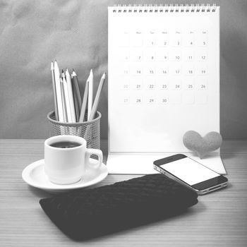 office desk : coffee with phone,wallet,calendar,heart,color pencil box on wood background black and white color