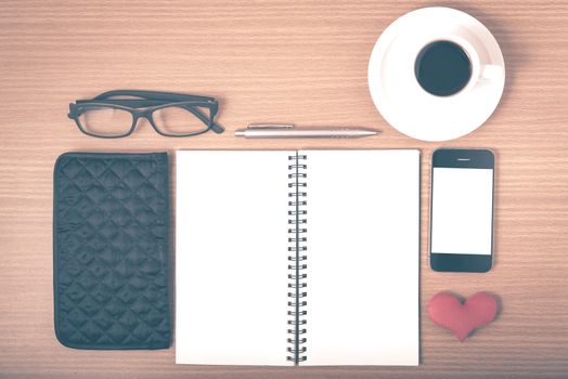 office desk : coffee with phone,notepad,eyeglasses,wallet,heart on wood background vintage style