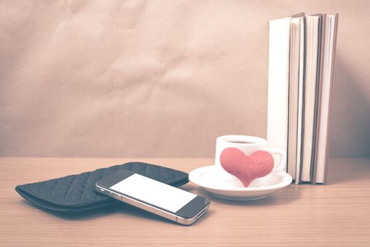 working table : coffee with phone,stack of book,wallet and heart on wood background vintage style