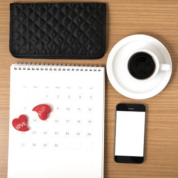 office desk : coffee with phone,calendar,wallet,heart on wood background