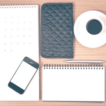desktop : coffee with phone,notepad,wallet,calendar on wood background vintage style