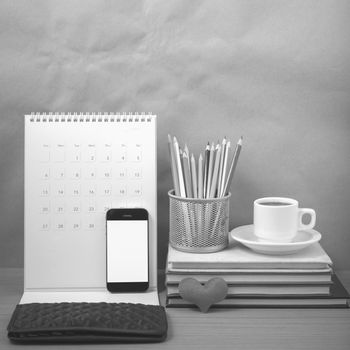 office desk : coffee with phone,wallet,calendar,heart,color pencil box,stack of book,heart on wood background black and white color