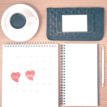 office desk : coffee with phone,wallet,calendar,heart,notepad on wood background vintage style