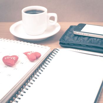 office desk : coffee with phone,wallet,calendar,heart,notepad on wood background vintage style