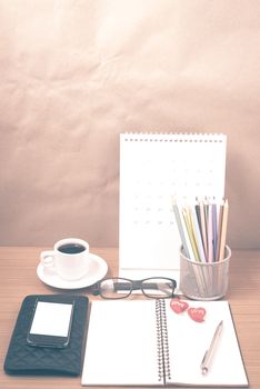 office desk : coffee with phone,wallet,calendar,color pencil box,notepad,heart on wood background vintage style