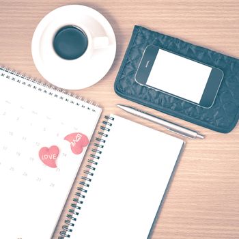 office desk : coffee with phone,wallet,calendar,heart,notepad on wood background vintage style