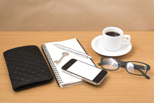 coffee and phone with notepad,key,eyeglasses and wallet on wood table background