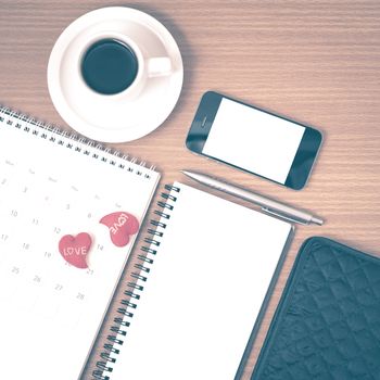 office desk : coffee with phone,wallet,calendar,heart,notepad on wood background vintage style