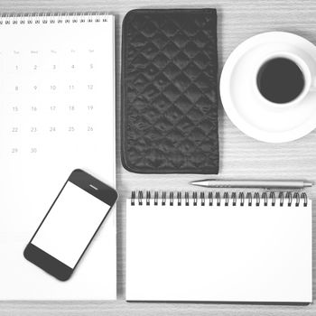 desktop : coffee with phone,notepad,wallet,calendar on wood background black and white color