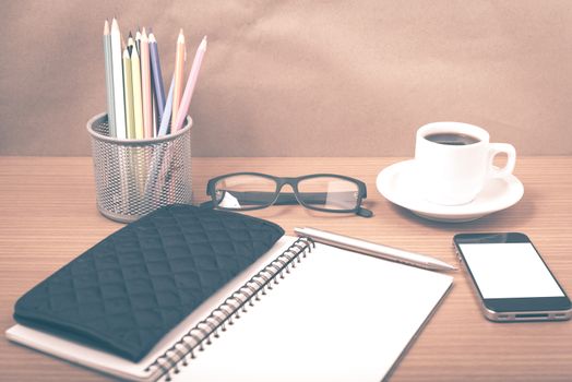 office desk : coffee with phone,notepad,eyeglasses,wallet,color pencil box on wood background vintage style