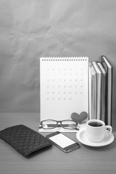 desktop : coffee with phone,stack of book,wallet,heart,eyeglasses,calendar on wood background black and white color