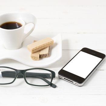 coffee cup with wafer,phone,eyeglasses on white wood background