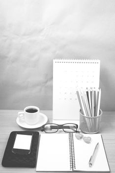 office desk : coffee with phone,wallet,calendar,color pencil box,notepad,heart on wood background black and white color