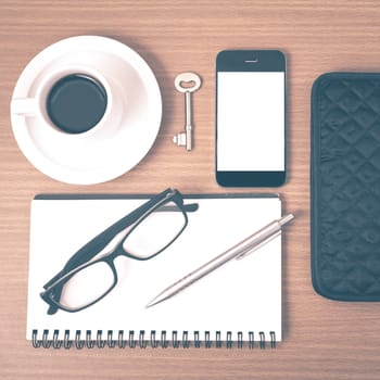 coffee and phone with notepad,key,eyeglasses and wallet on wood table background vintage style