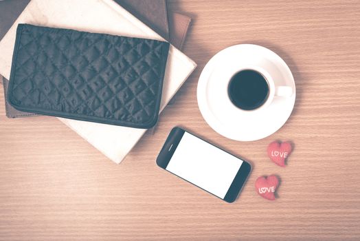 office desk : coffee with phone,stack of book,wallet on wood background vintage style