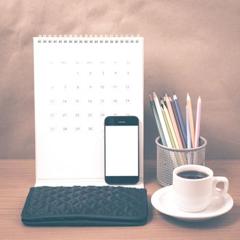 office desk : coffee with phone,calendar,wallet,color pencil on wood background vintage style