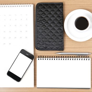 desktop : coffee with phone,notepad,wallet,calendar on wood background