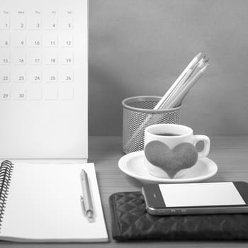 office desk : coffee with phone,wallet,calendar,heart,color pencil box,notepad,heart on wood background black and white color