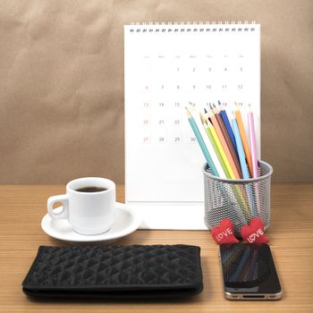 office desk : coffee with phone,wallet,calendar,heart,color pencil box on wood background