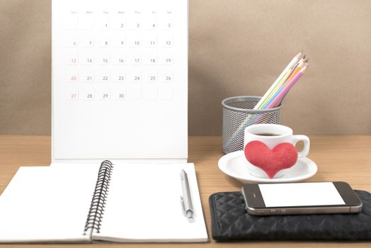 office desk : coffee with phone,wallet,calendar,heart,color pencil box,notepad,heart on wood background