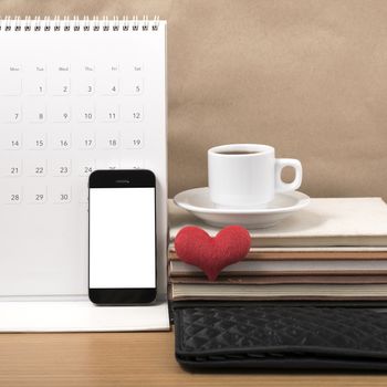 office desk : coffee with phone,wallet,calendar,heart,stack of book on wood background