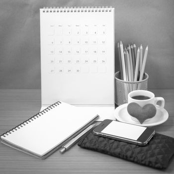 office desk : coffee with phone,wallet,calendar,heart,color pencil box,notepad,heart on wood background black and white color