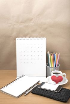 office desk : coffee with phone,wallet,calendar,heart,color pencil box,notepad,heart on wood background