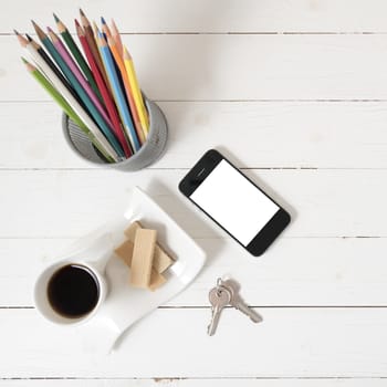 coffee cup with wafer,phone,pencil box,key on white wood background