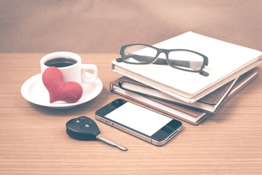 office desk : coffee and phone with car key,eyeglasses,stack of book,heart vintage style