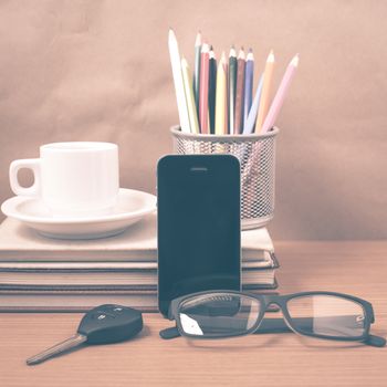 office desk : coffee and phone with car key,eyeglasses,stack of book,pencil box vintage style