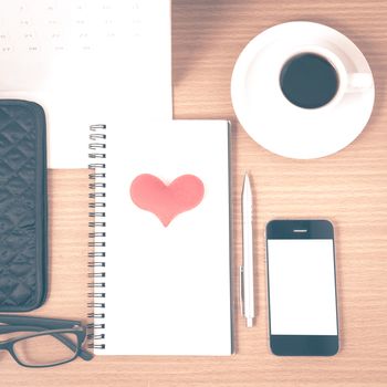 office desk : coffee with phone,wallet,calendar,heart,notepad,eyeglasses,heart on wood background vintage style