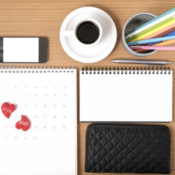 office desk : coffee with phone,wallet,calendar,heart,color pencil box,notepad on wood background