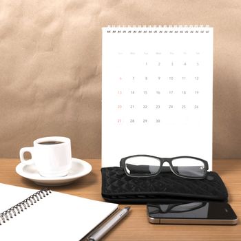 office desk : coffee with phone,calendar,wallet,notepad on wood background