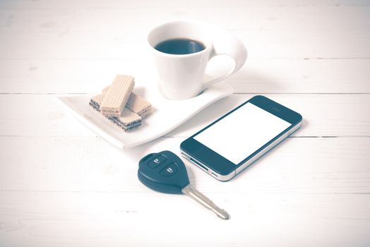 coffee cup with wafer,phone,car key on white wood background vintage style