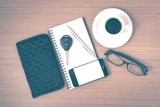 coffee and phone with notepad,car key,eyeglasses and wallet on wood table background vintage style