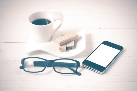 coffee cup with wafer,phone,eyeglasses on white wood background vintage style