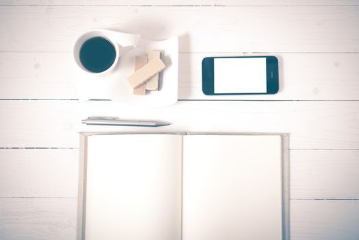 coffee cup with wafer,phone,notebook on white wood background vintage style