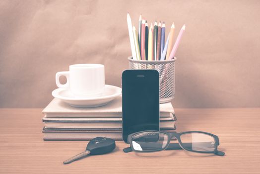 office desk : coffee and phone with car key,eyeglasses,stack of book,pencil box vintage style