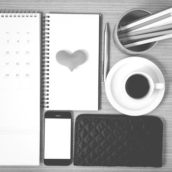 office desk : coffee with phone,wallet,calendar,heart,color pencil box,notepad,heart on wood background black and white color