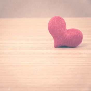 red heart on wood table background vintage style