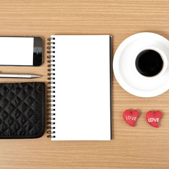 working table : coffee with phone,notepad,wallet and red heart on wood background