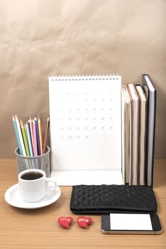 office desk : coffee with phone,wallet,calendar,heart,color pencil box,stack of book,heart on wood background