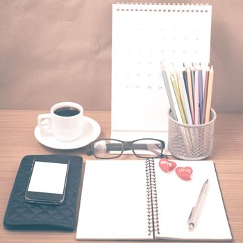 office desk : coffee with phone,wallet,calendar,color pencil box,notepad,heart on wood background vintage style
